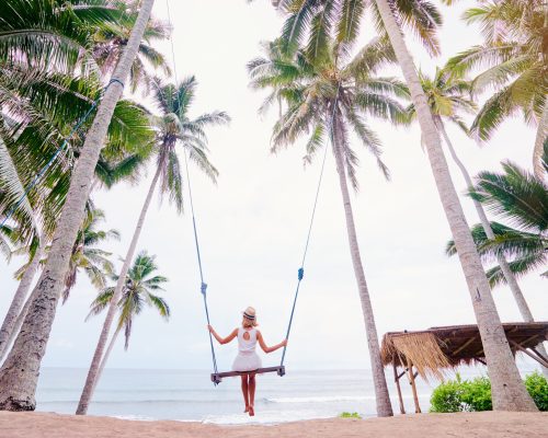 Lady on a swing by the beach. She got a personal loan to make this holiday happen.
